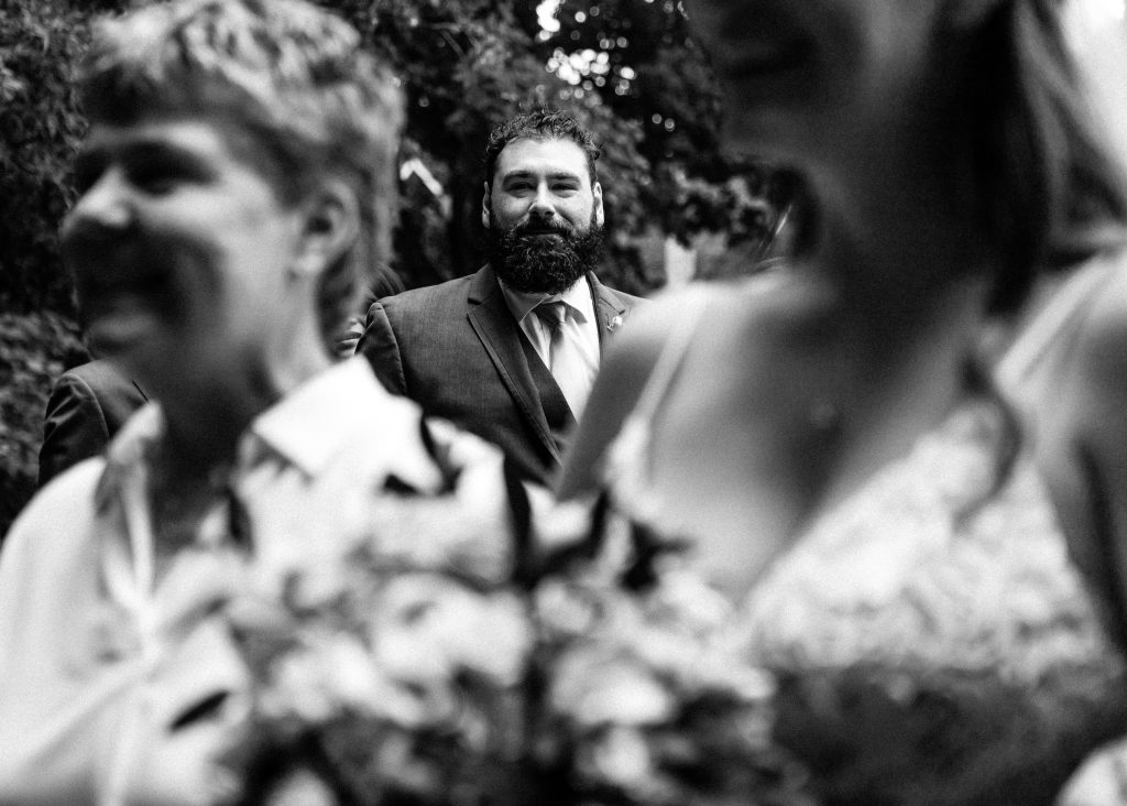 intimate home wedding as bride walks down the aisle with her brother looking on photographed by intimate wedding photographer heather doughty photography